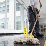 Office cleaner cleaning floor